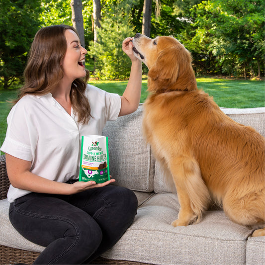 woman feeding her dog greenies immune health supplements